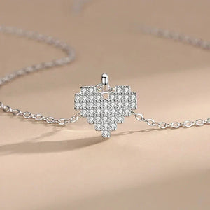 Silver necklace with a heart-shaped pendant on a beige background