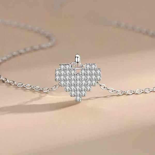 Silver necklace with a heart-shaped pendant on a beige background