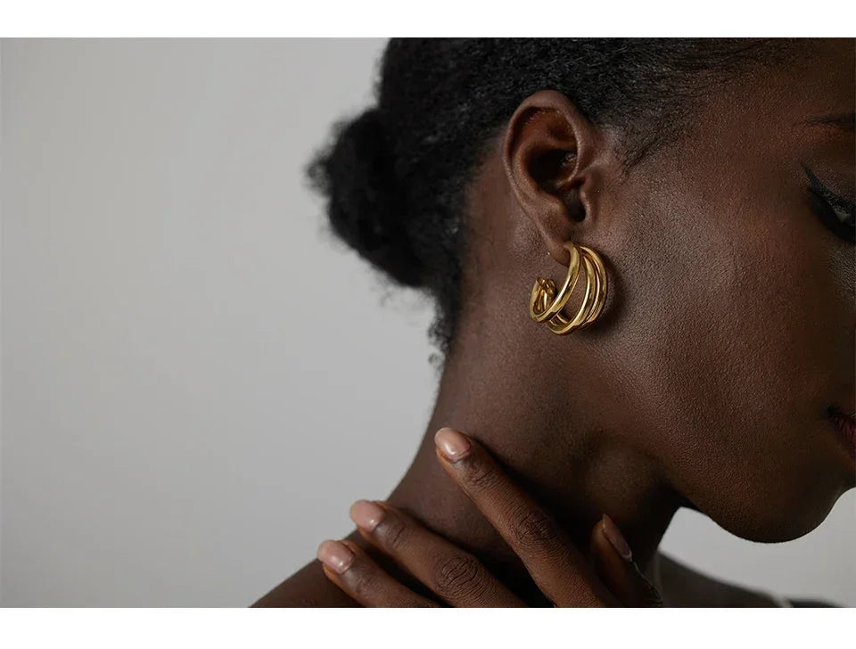 Woman wearing elegant gold-plated hoop earrings, close-up jewelry photography