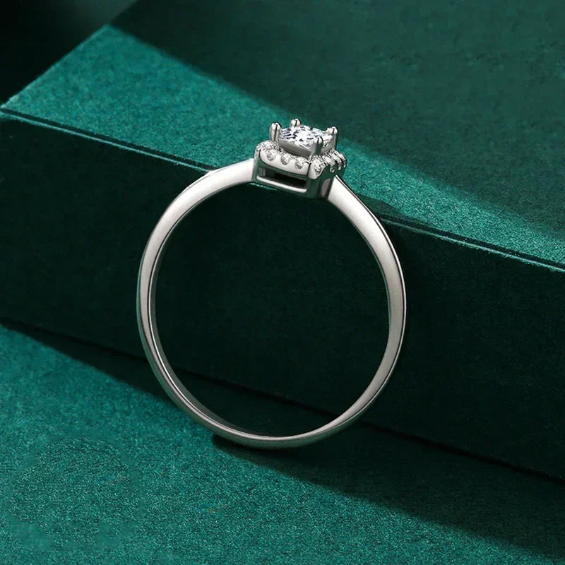 Elegant 925 silver solitaire ring with round gemstone and delicate prong setting on green background