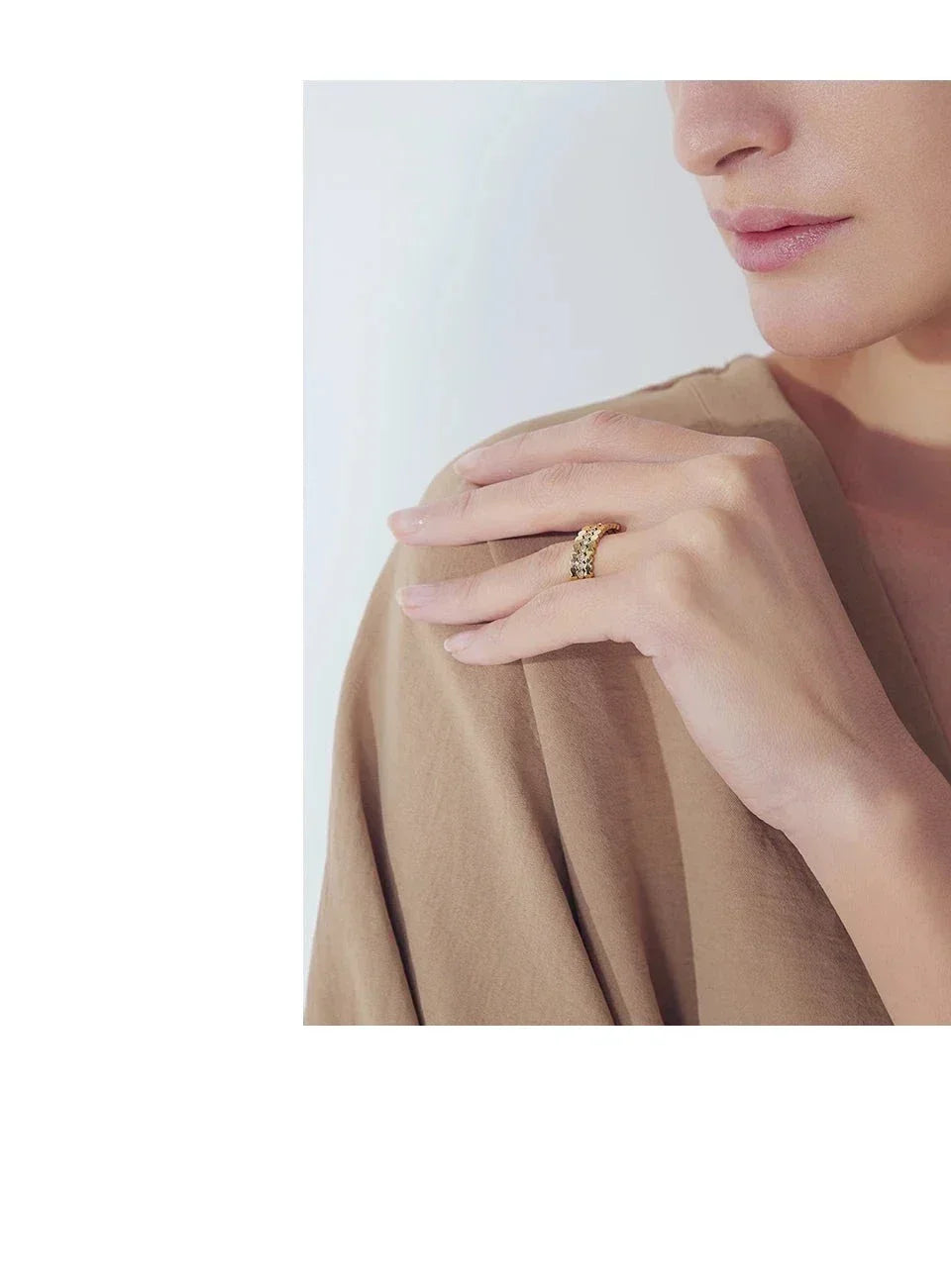 Woman wearing elegant 18K gold-plated textured ring on finger, neutral background