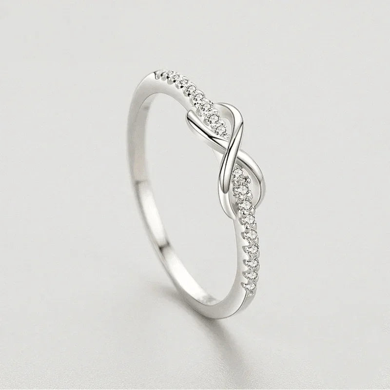 Elegant 925 silver infinity ring with pavé cubic zirconia on a light background