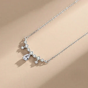 Crystal Dew Pendant - TM & Co. Jewels- Silver necklace with a teardrop-shaped pendant on a beige background.
