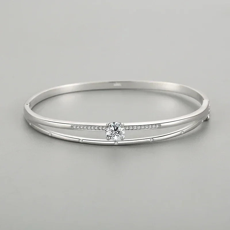 925 silver bangle bracelet with sparkling center stone and delicate pavé accents on gray background