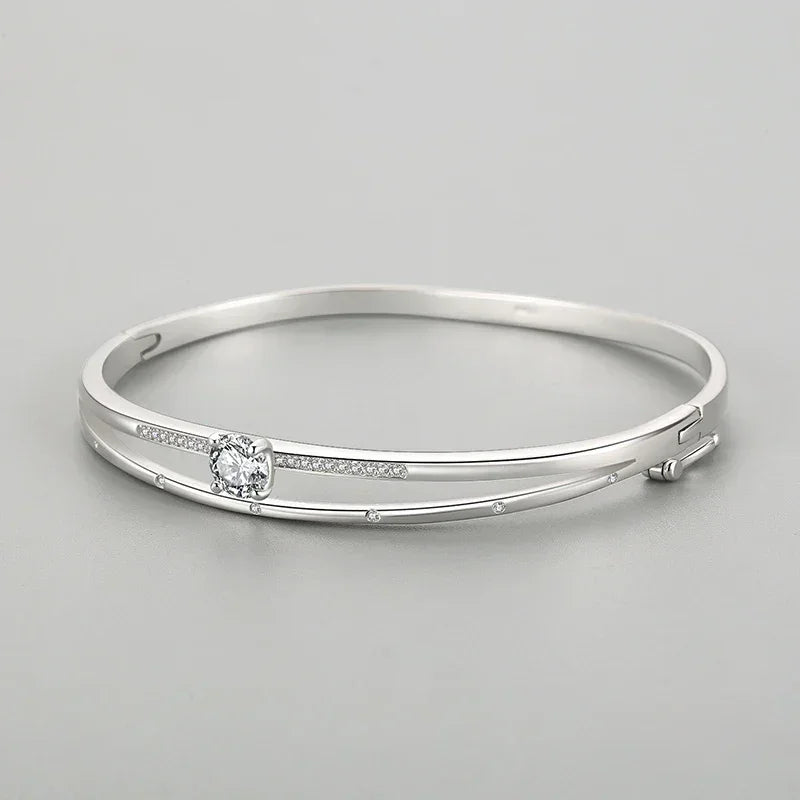 Elegant 925 silver bangle bracelet with sparkling cubic zirconia accents on a gray background