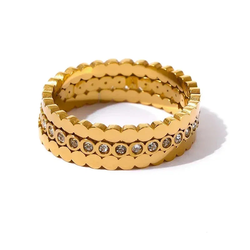 Gold-plated scalloped edge stacking rings set with clear gemstones on white background