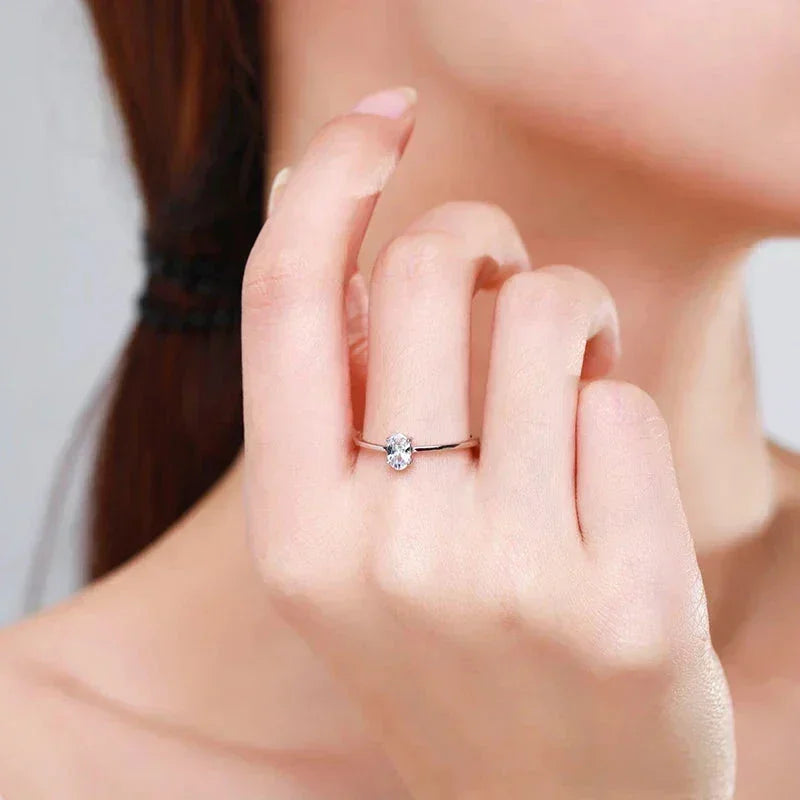 Elegant woman’s hand modeling a delicate 925 silver solitaire ring with clear gemstone