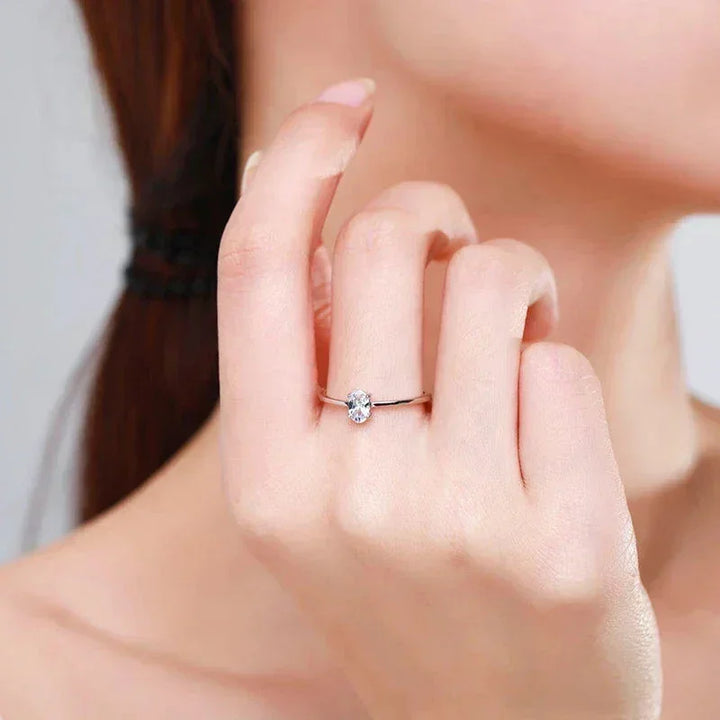 Elegant woman’s hand modeling a delicate 925 silver solitaire ring with clear gemstone