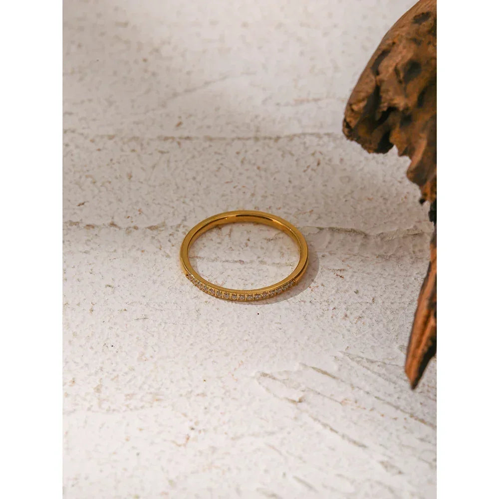 18K gold-plated silver ring with small pavé stones on textured white background