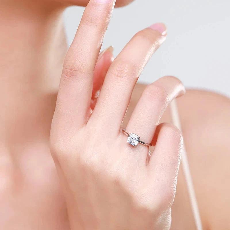 Woman’s hand wearing a solitaire 925 silver ring with square clear gemstone