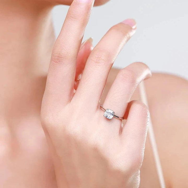 Woman’s hand wearing a solitaire 925 silver ring with square clear gemstone