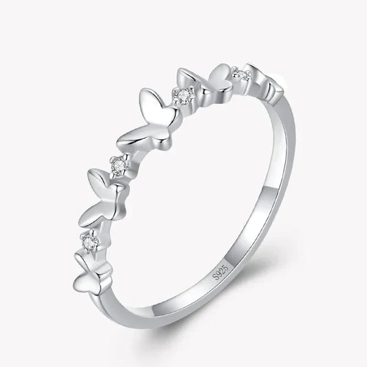 Silver ring with butterfly designs and small diamonds on a white background