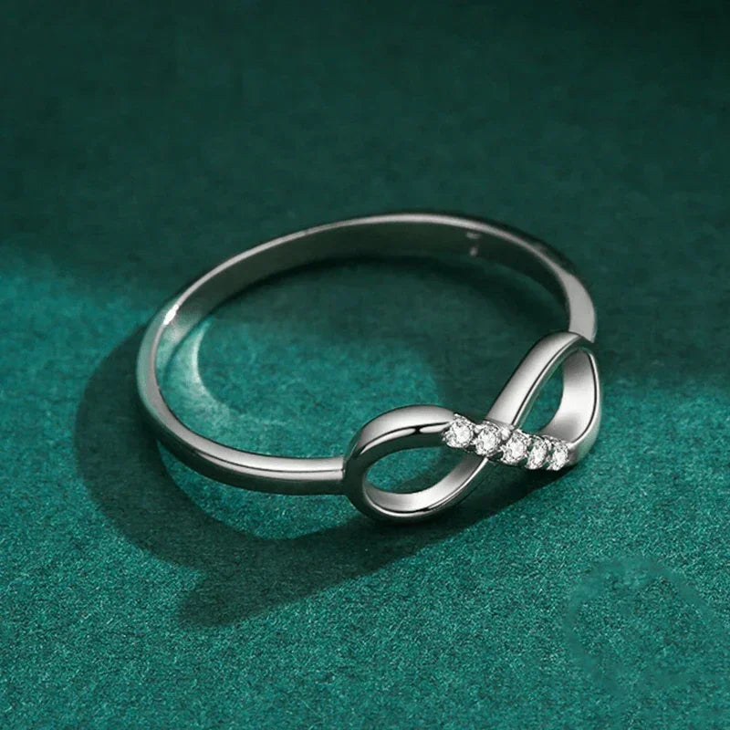 Sterling silver infinity ring with small diamonds on green background