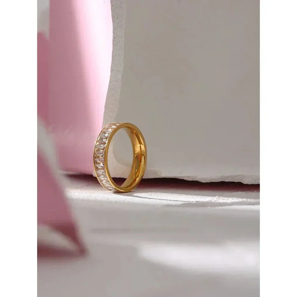 18K gold-plated ring with sparkling stones in a minimalist studio setting
