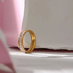 18K gold-plated ring with sparkling stones in a minimalist studio setting