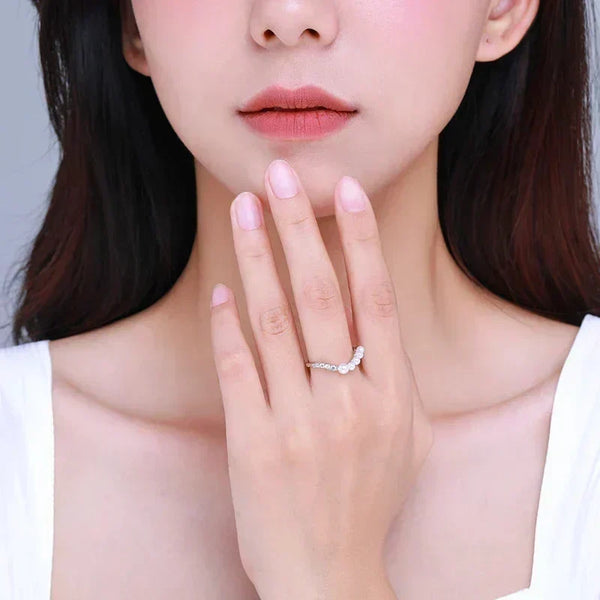 Woman wearing a delicate 925 silver ring with gemstones on her finger