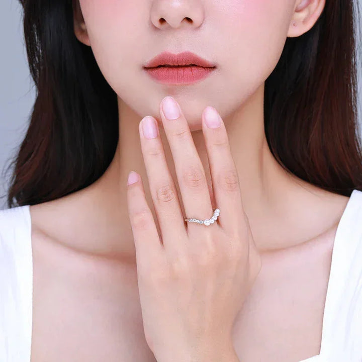 Woman wearing a delicate 925 silver ring with gemstones on her finger