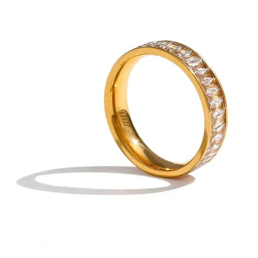 Gold-plated silver ring with embedded clear stones on white background