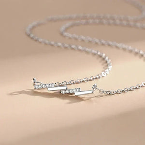Silver necklace with a clasp on a beige background