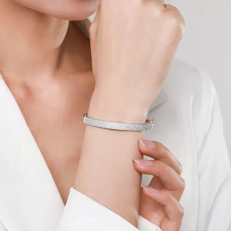 Woman wearing an elegant 925 silver textured bracelet on wrist, white blazer background