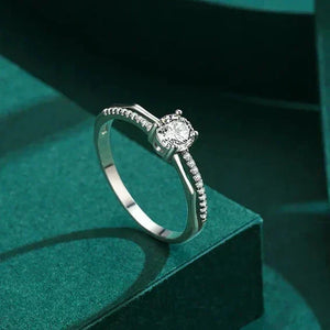 Silver ring with a diamond on a green surface, labeled 'Real Shotshow'.