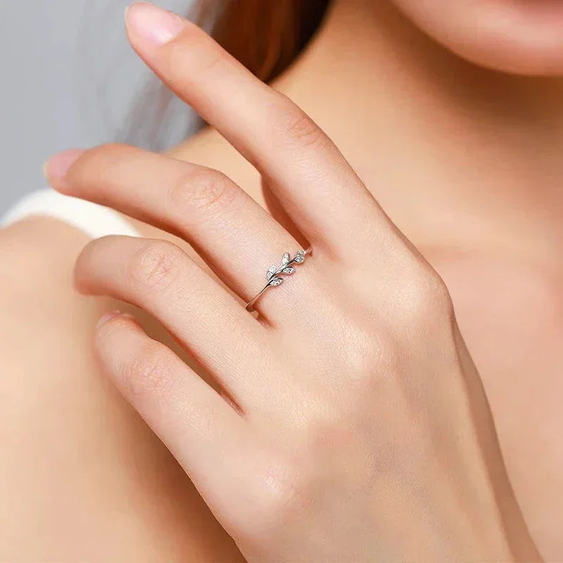 Delicate 925 silver leaf ring with cubic zirconia on woman's hand, minimalist jewelry