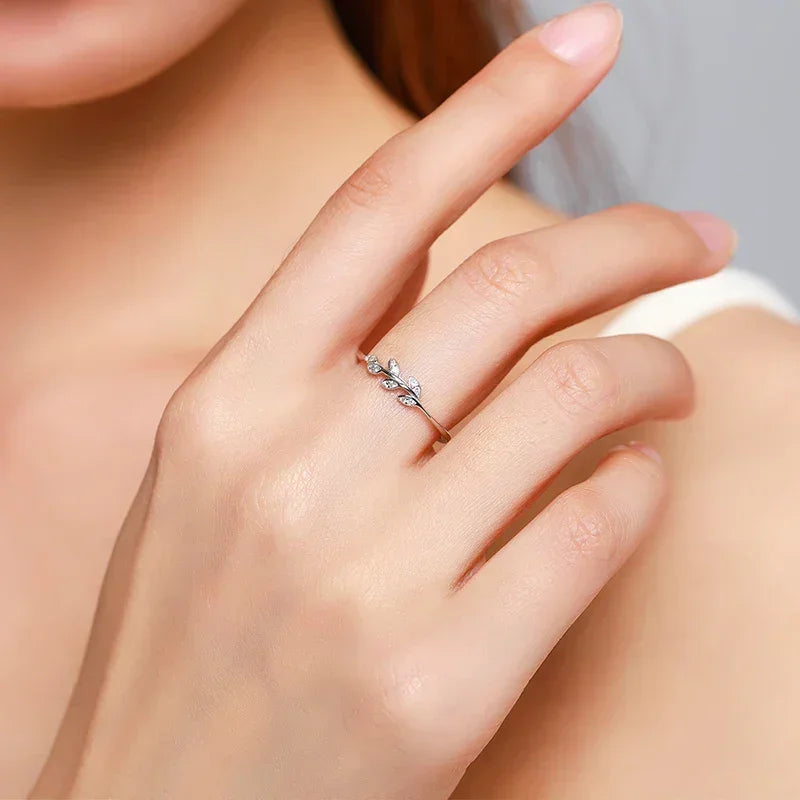 Woman wearing a delicate 925 silver leaf design ring on her finger
