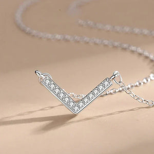 Silver V-shaped necklace with clear stones on a beige background-Prism Glow Pendant - TM & CO. JEWELS 