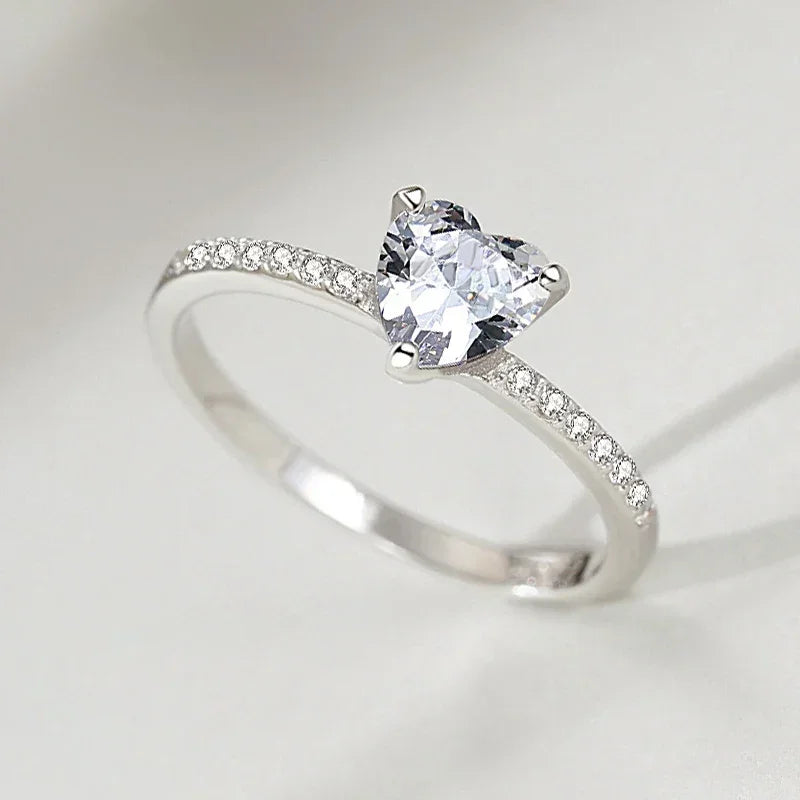 925 silver ring with heart-shaped clear gemstone and pavé band on white background