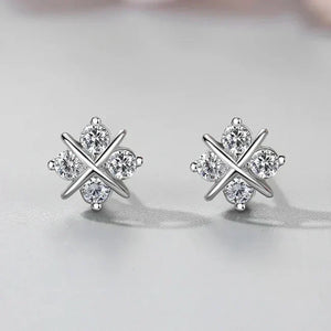 Pair of silver earrings with a star design on a light gray background