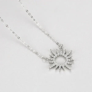 Silver necklace with a star-shaped pendant on a light gray background