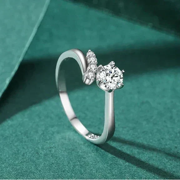 925 silver ring with round-cut center stone and side accent cubic zirconia on a white background