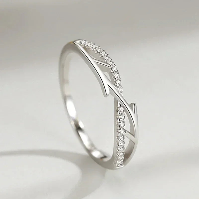 Sterling silver ring with thorn branch design and pavé cubic zirconia on a light background