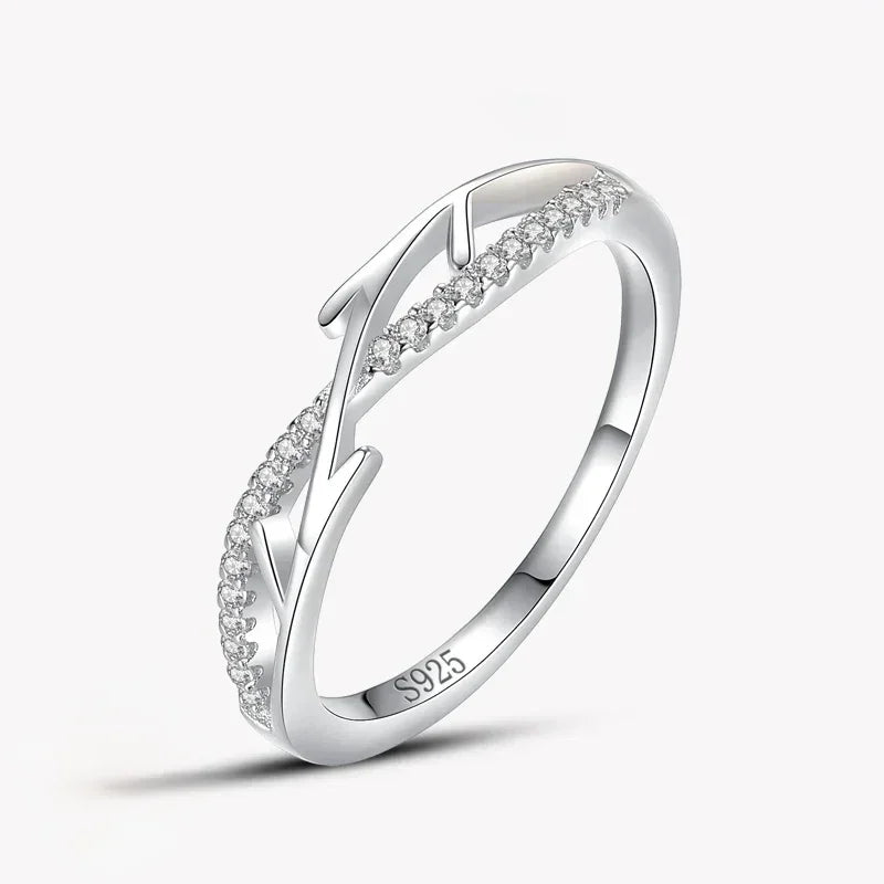 Sterling silver ring with leaf design and small clear stones set on a white background