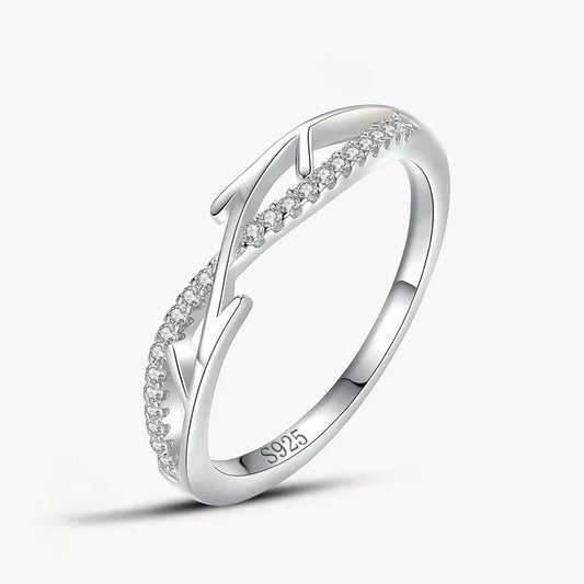 Sterling silver ring with leaf design and small clear stones set on a white background