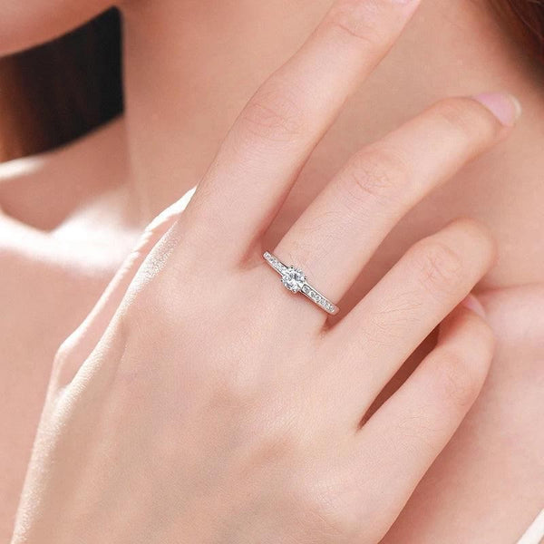 Hand wearing a 925 silver solitaire ring with a round center stone and side accents