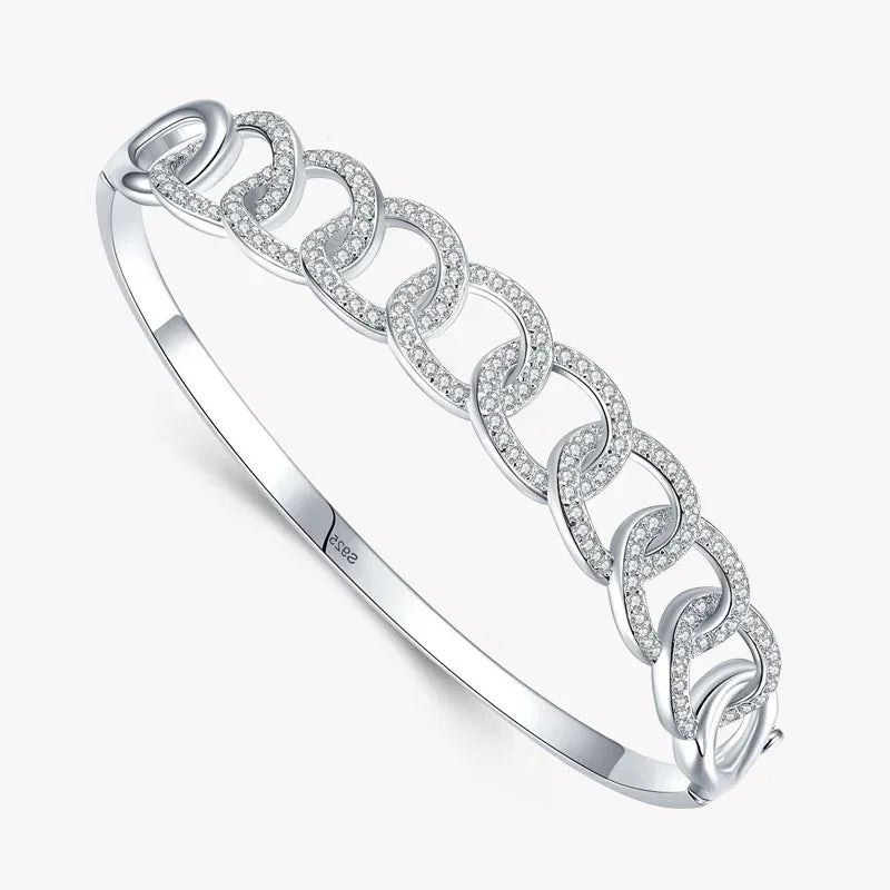 Sterling silver bangle with interlocking links and pavé cubic zirconia accents on white background