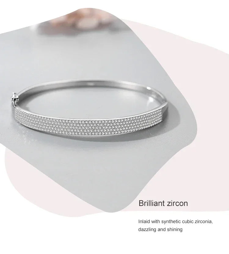 Sterling silver bangle bracelet inlaid with brilliant cubic zirconia stones on a light background