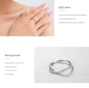 Elegant S925 silver wave ring with cubic zirconia, worn on woman's hand, close-up view