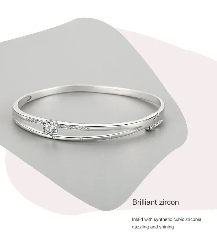 Elegant silver bangle bracelet with cubic zirconia accents on a modern, minimal background.