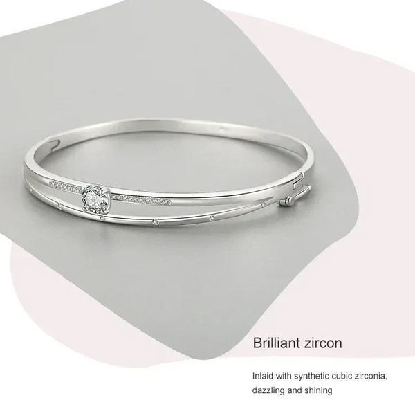 Elegant silver bangle bracelet with cubic zirconia accents on a modern, minimal background.