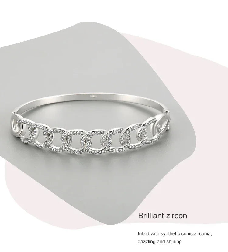 Sterling silver chain link bracelet with cubic zirconia accents on minimalist background