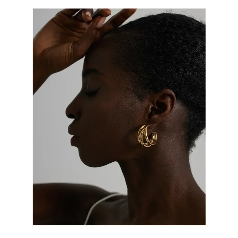 Woman wearing layered gold hoop earrings, elegant jewelry for women