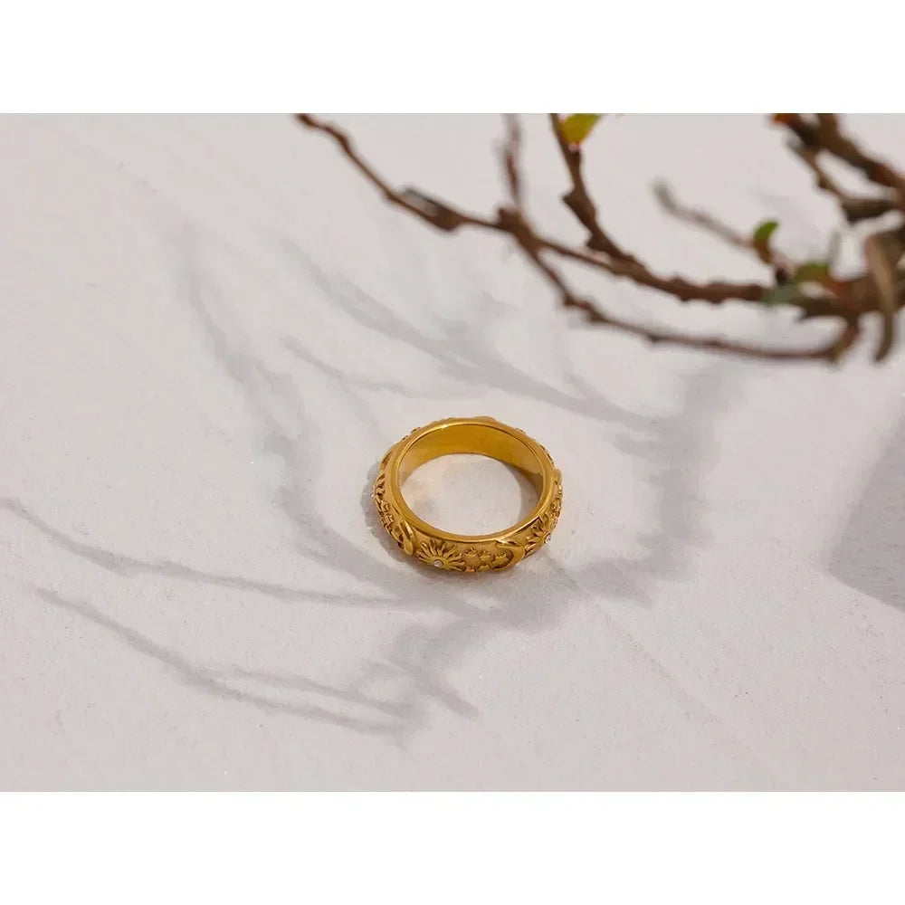 18K gold-plated floral engraved ring on light surface with tree branch shadow