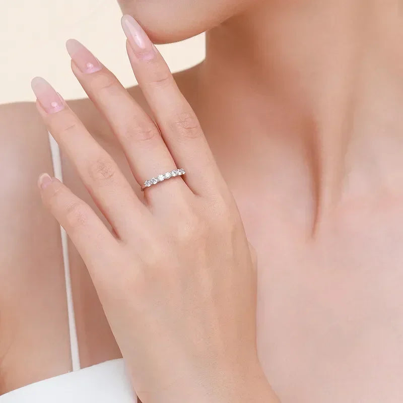 Woman wearing elegant 925 silver eternity ring with sparkling stones on her finger