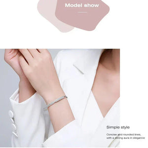 Hand wearing a silver bracelet with a plain background-Ava Heart Bands - TM & CO. JEWELS 