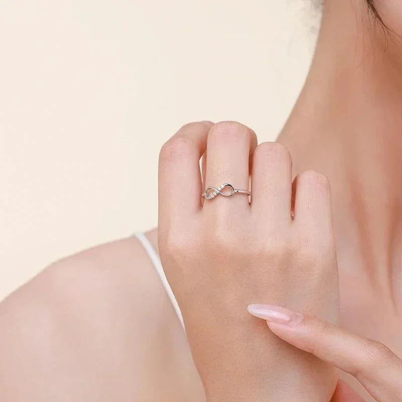 Woman wearing a 925 silver infinity ring with subtle gemstone accents, elegant jewelry