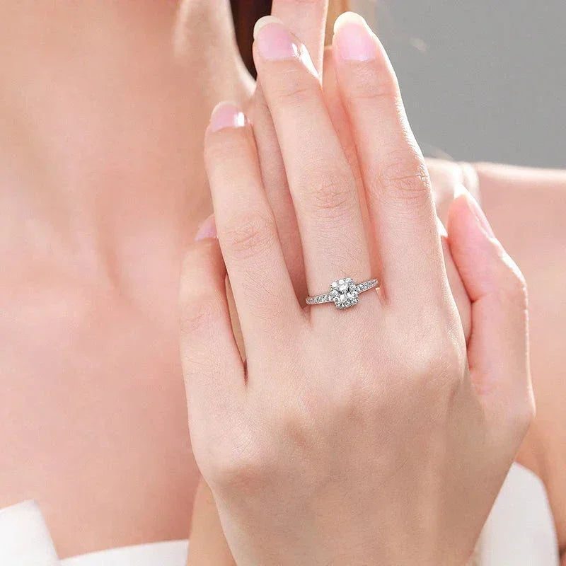 Woman wearing elegant 925 silver ring with round cut center stone and pavé band
