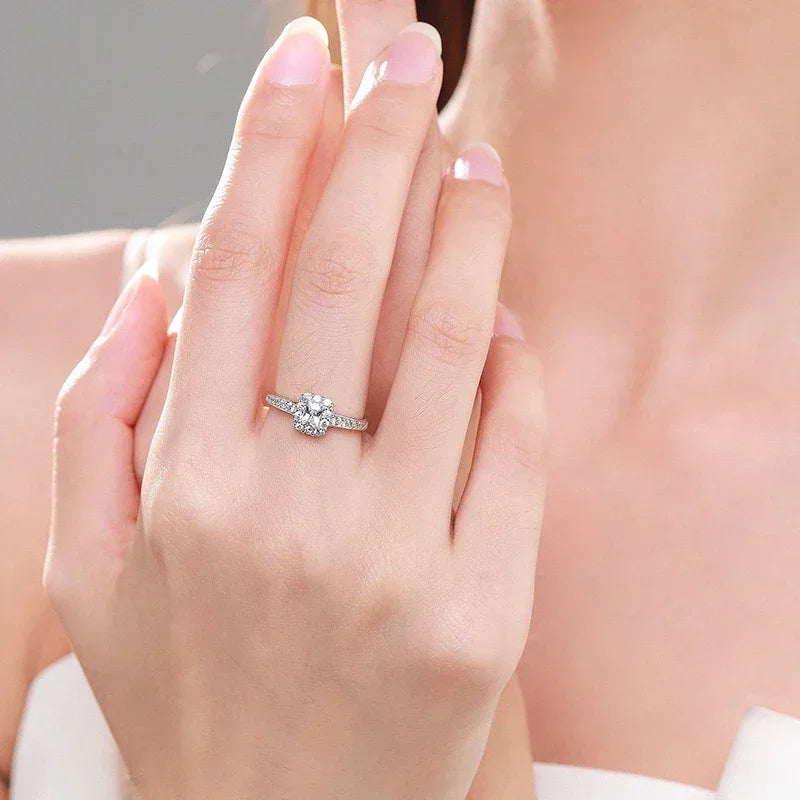 Woman's hand wearing a 925 silver ring with a sparkling solitaire stone and pavé band