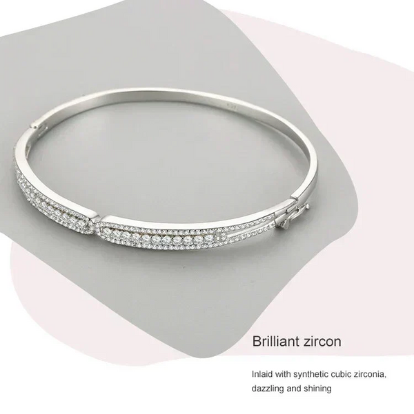 Silver bracelet with zircon stones on a gray background